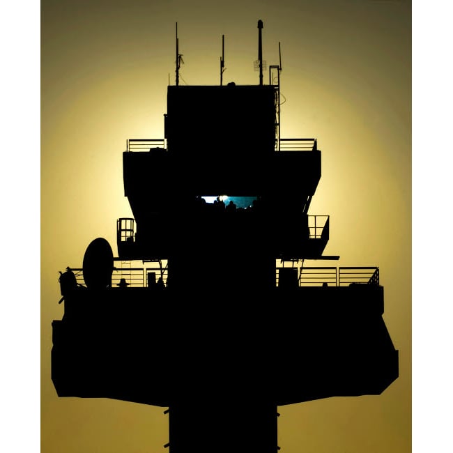 The setting sun silhouettes an air traffic control tower Poster Print by Stocktrek Images Image 2