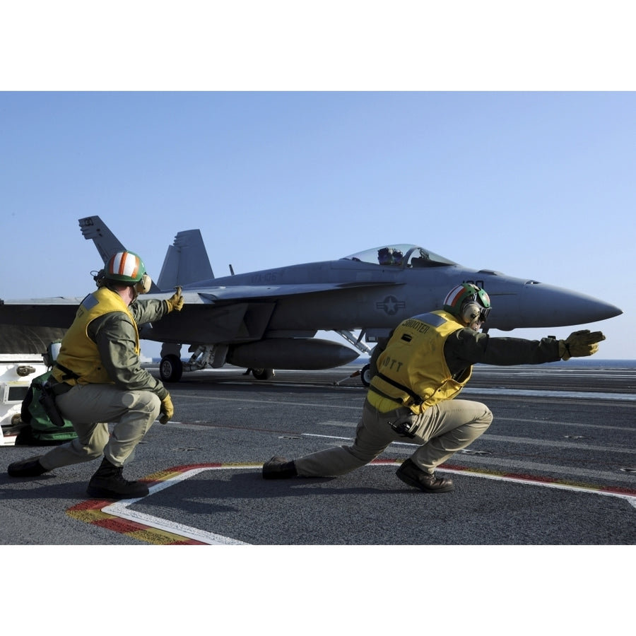 Shooters aboard the USS George H.W. Bush give the go-ahead signal to launch an F/A-18 Super Hornet Print Image 1