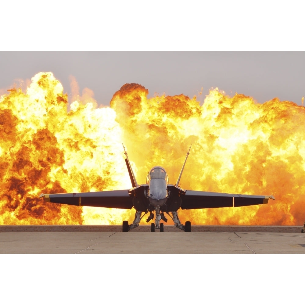 An F/A-18 Hornet sits on the flight line as a wall of fire detonates behind it Poster Print Image 1