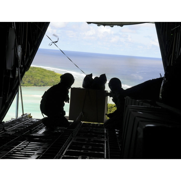 Airmen push out a pallet of donated goods from a C-130 Hercules Poster Print Image 2