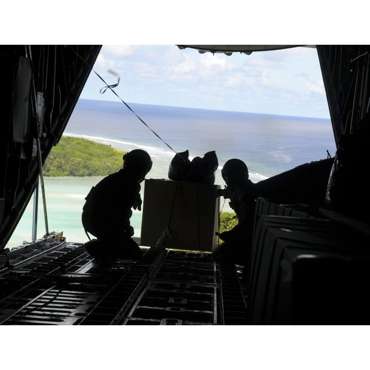 Airmen push out a pallet of donated goods from a C-130 Hercules Poster Print Image 1