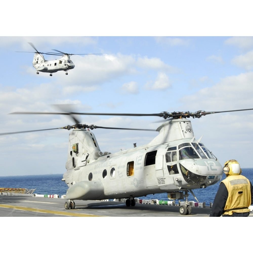 A CH-46E Sea Knight helicopter takes off from the flight deck of USS Essex Poster Print Image 1