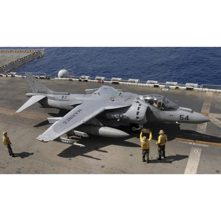 A pilot receives signals from air handlers before take-off during AV-8B Harrier flight operations Print Image 1