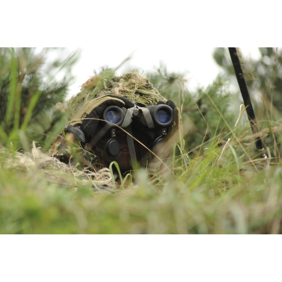 A German Bundeswehr soldier camouflages himself to blend into his surroundings Poster Print Image 1