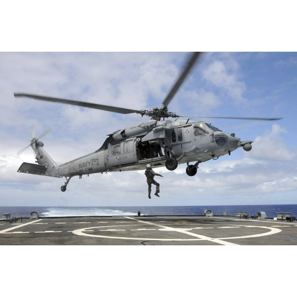 A naval aircrewman is hoisted into an MH-60S Sea Hawk helicopter Poster Print Image 1