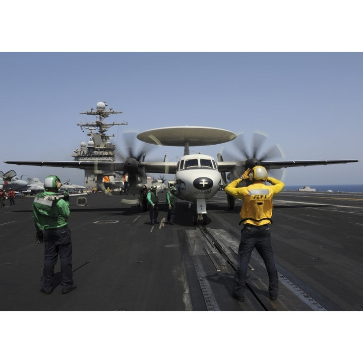 A plane director guides an E-2C Hawkeye onto the catapult for launch Poster Print Image 1