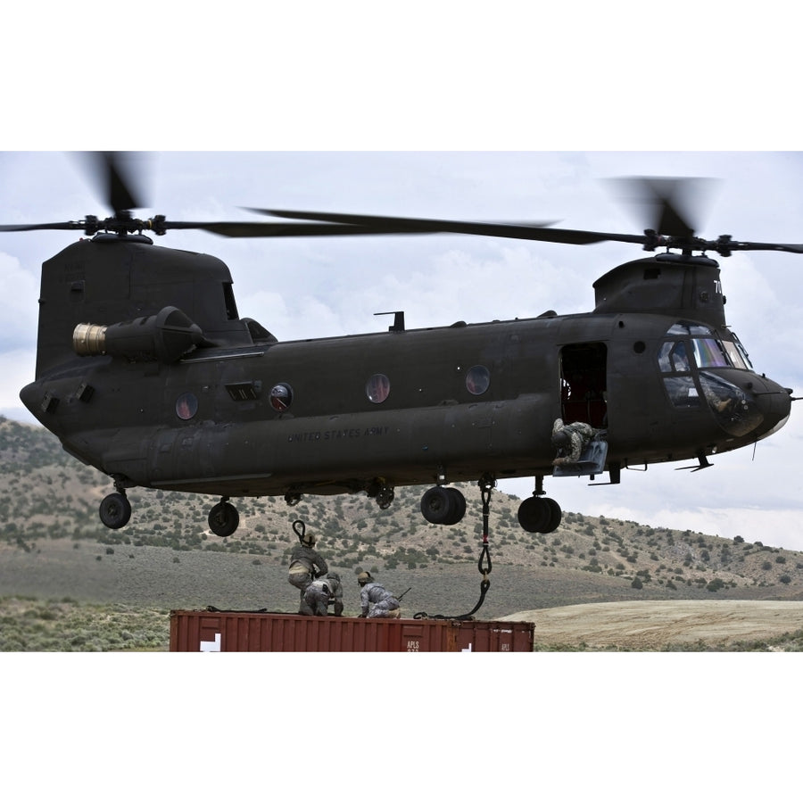 Personnel attach a storage container to a CH-47 Chinook helicopter Poster Print Image 1