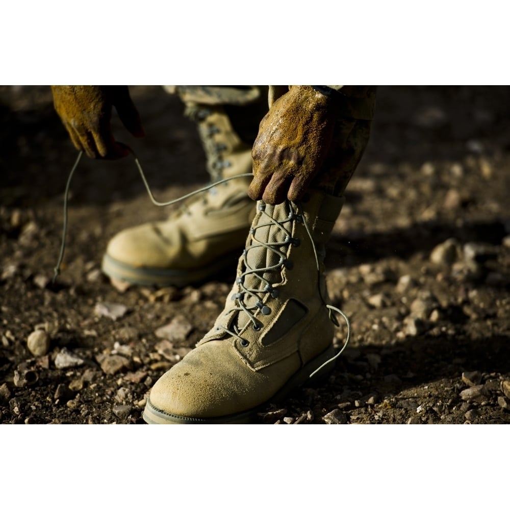 An Air Force Basic Military Training trainee reties his boots Poster Print Image 1