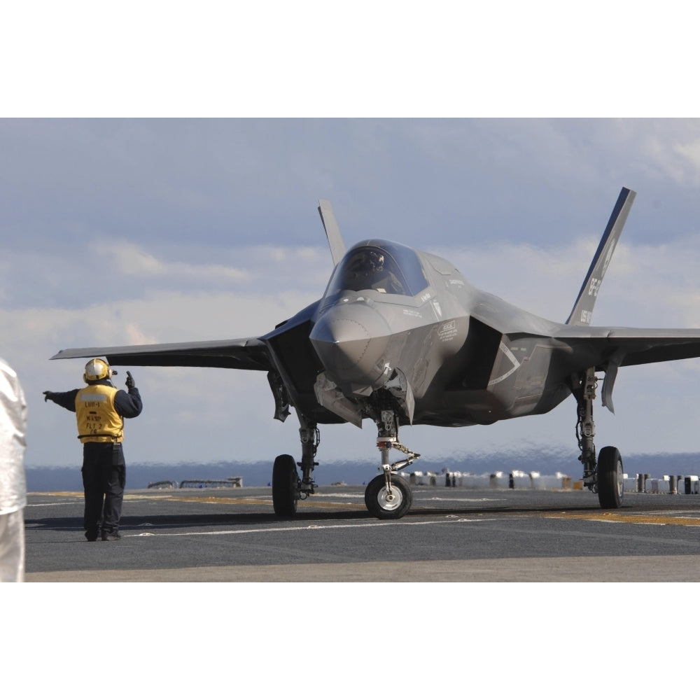 An aviation boatswains mate directs an F-35B Lightning II aboard USS Wasp Poster Print Image 1