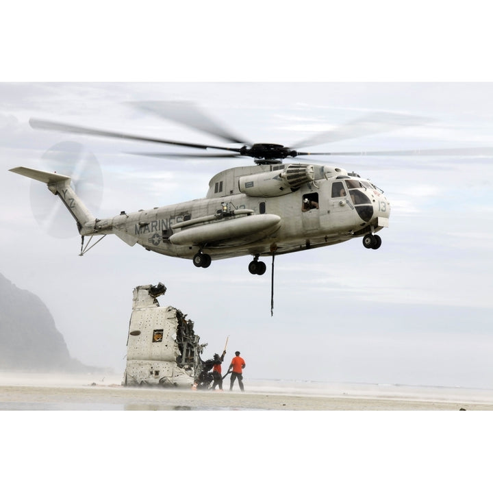 U.S. Sailors assist a CH-53D Sea Stallion helicopter in removing wreckage Poster Print Image 1