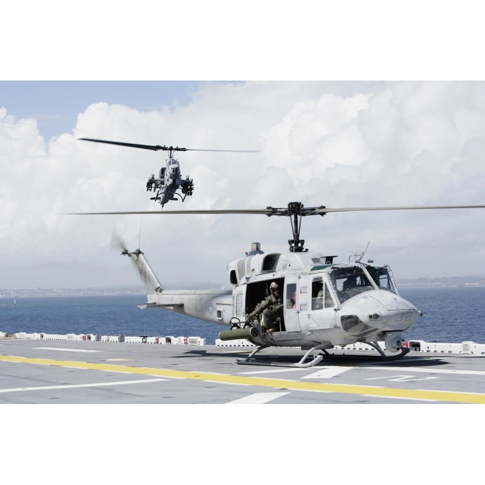 A UH-1N Huey and an AH-1W Super Cobra land on flight deck of USS Essex Poster Print Image 1