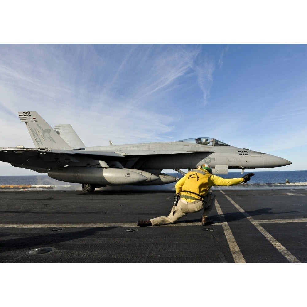 A shooter signals to launch an F/A-18E Super Hornet aboard USS Nimitz Poster Print Image 1