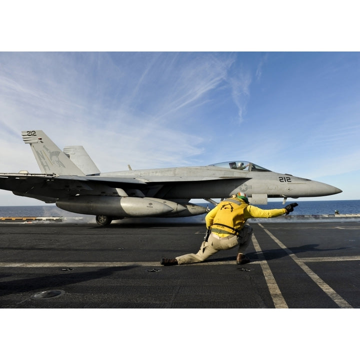 A shooter signals to launch an F/A-18E Super Hornet aboard USS Nimitz Poster Print Image 1