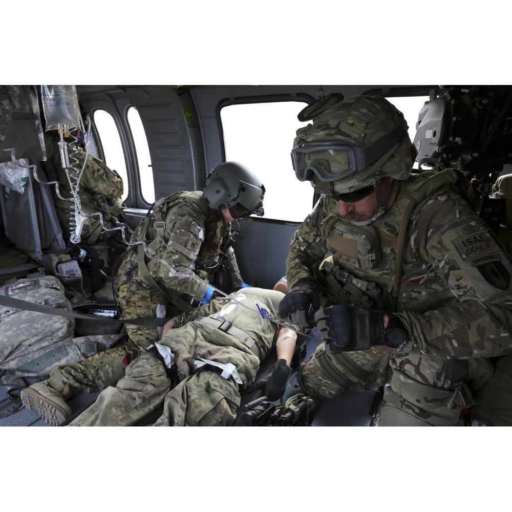 U.S. Army flight medics aid a simulated casulaty in a UH-60 Black Hawk Poster Print Image 1