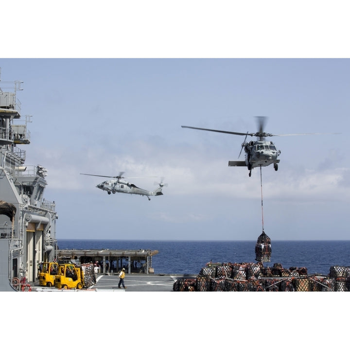 An MH-60S Sea Hawk picks up cargo from USNS Medgar Evers Poster Print Image 1