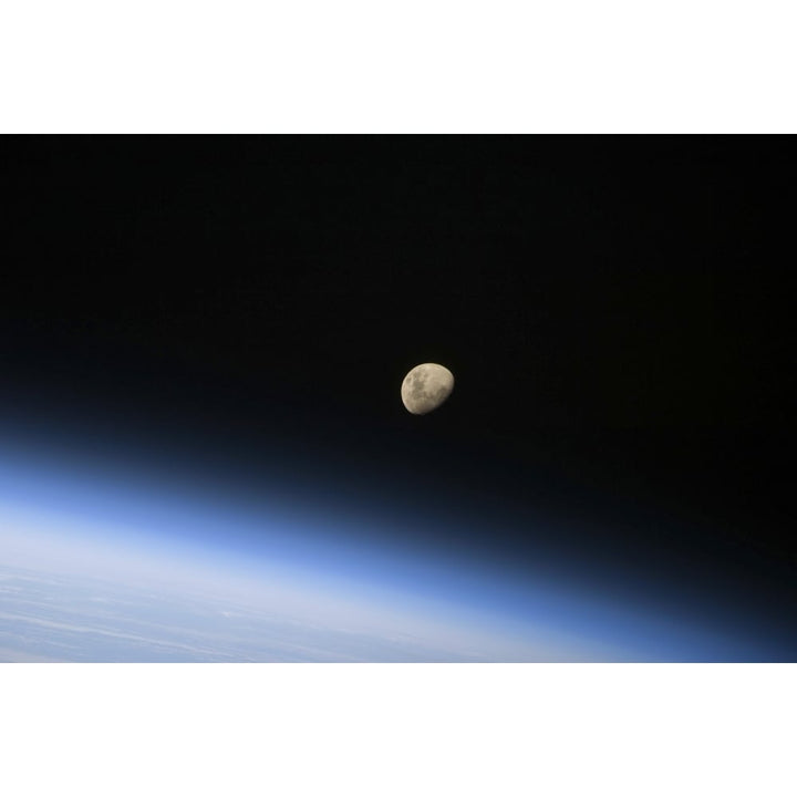 A gibbous moon visible above Earths atmosphere Poster Print Image 1