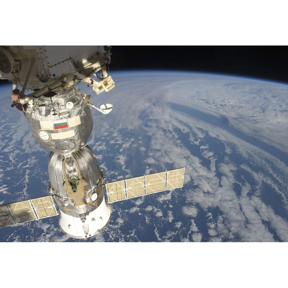 A docked Russian Soyuz spacecraft backdropped by Earth Poster Print Image 2