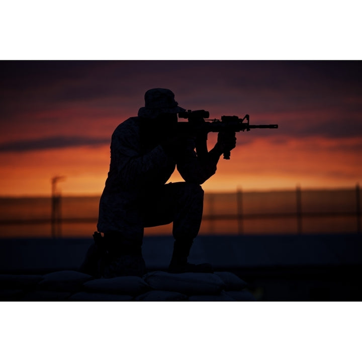 Silhouette of a U.S Marine on a bunker at sunset in Afghanistan Poster Print Image 1