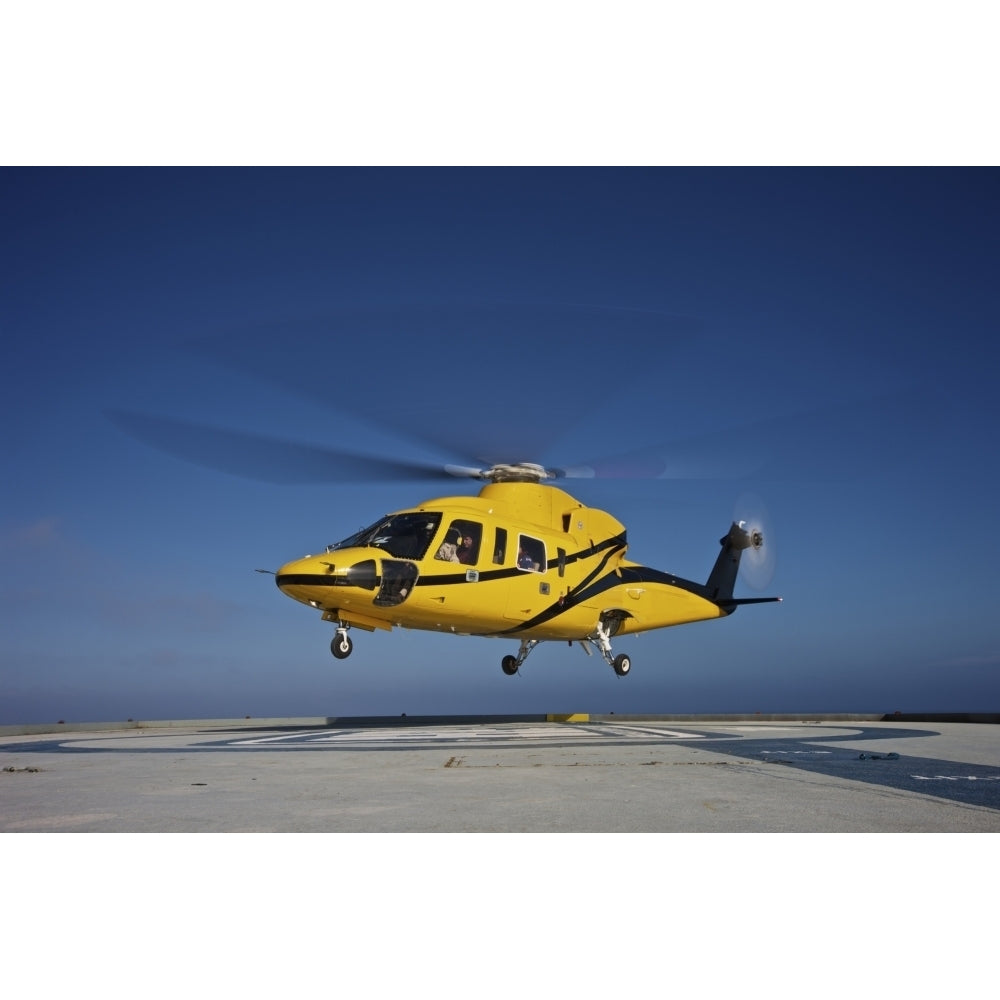 A Sikorsky S-76 utility helicopter taking off from an oil rig Poster Print Image 1