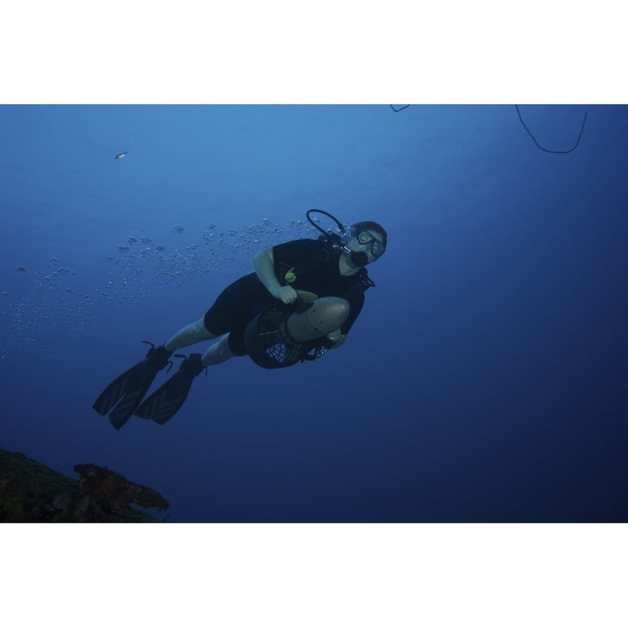 Scuba diver uses a diver propulsion vehicle off the coast of Bonaire Caribbean Netherlands Poster Print Image 1