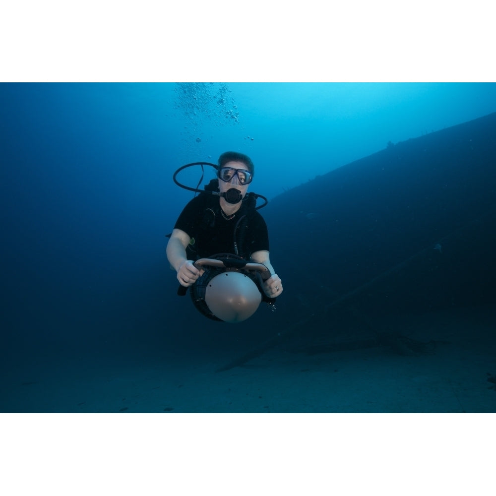 Scuba diver uses a diver propulsion vehicle to navigate the Hilma Hooker shipwreck Poster Print Image 2