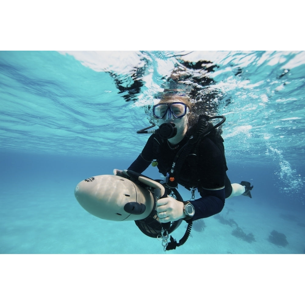 Scuba diver navigates the waters using a diver propulsion vehicle Poster Print Image 1