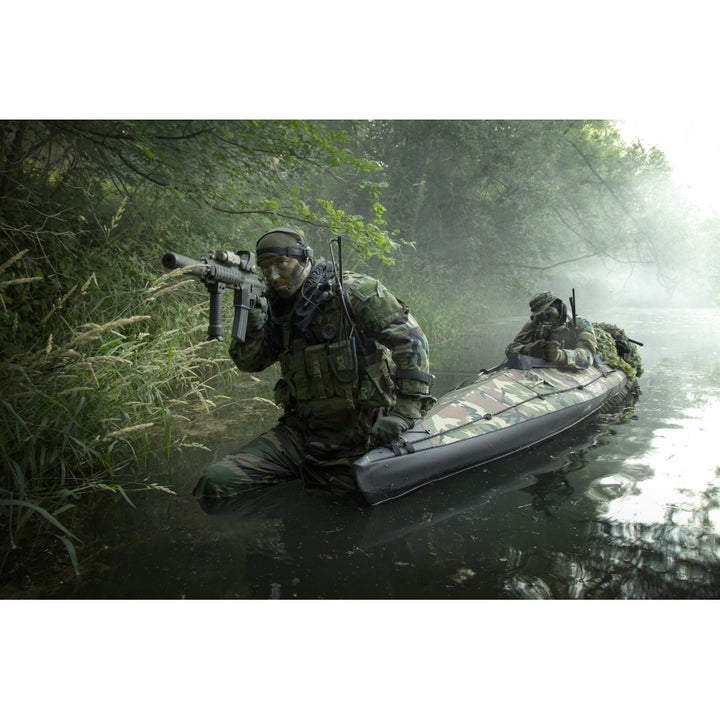 Navy SEALs navigate the waters in a folding kayak during jungle warfare operations Poster Print Image 1