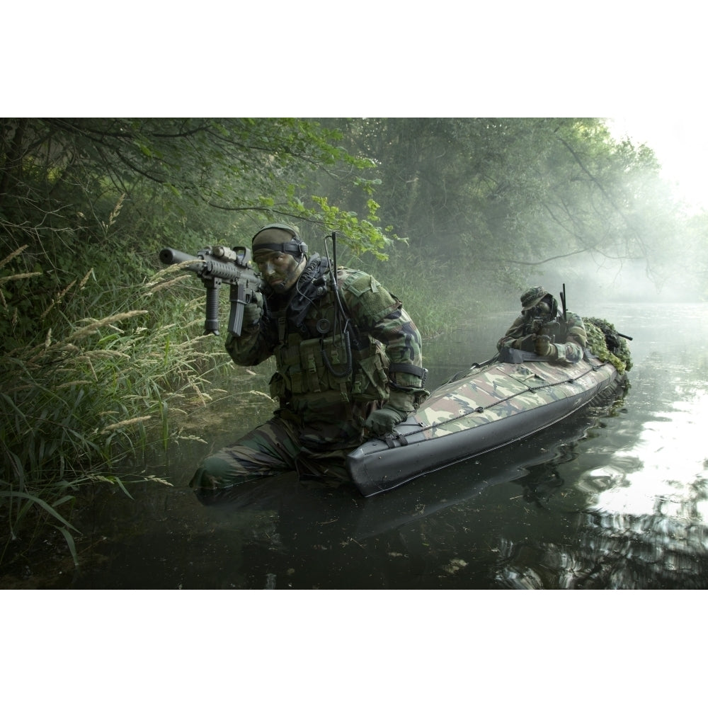 Navy SEALs navigate the waters in a folding kayak during jungle warfare operations Poster Print Image 2