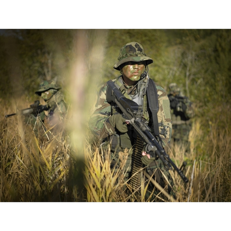 U.S. Navy SEALs walk through tall grass during combat operations Poster Print Image 1