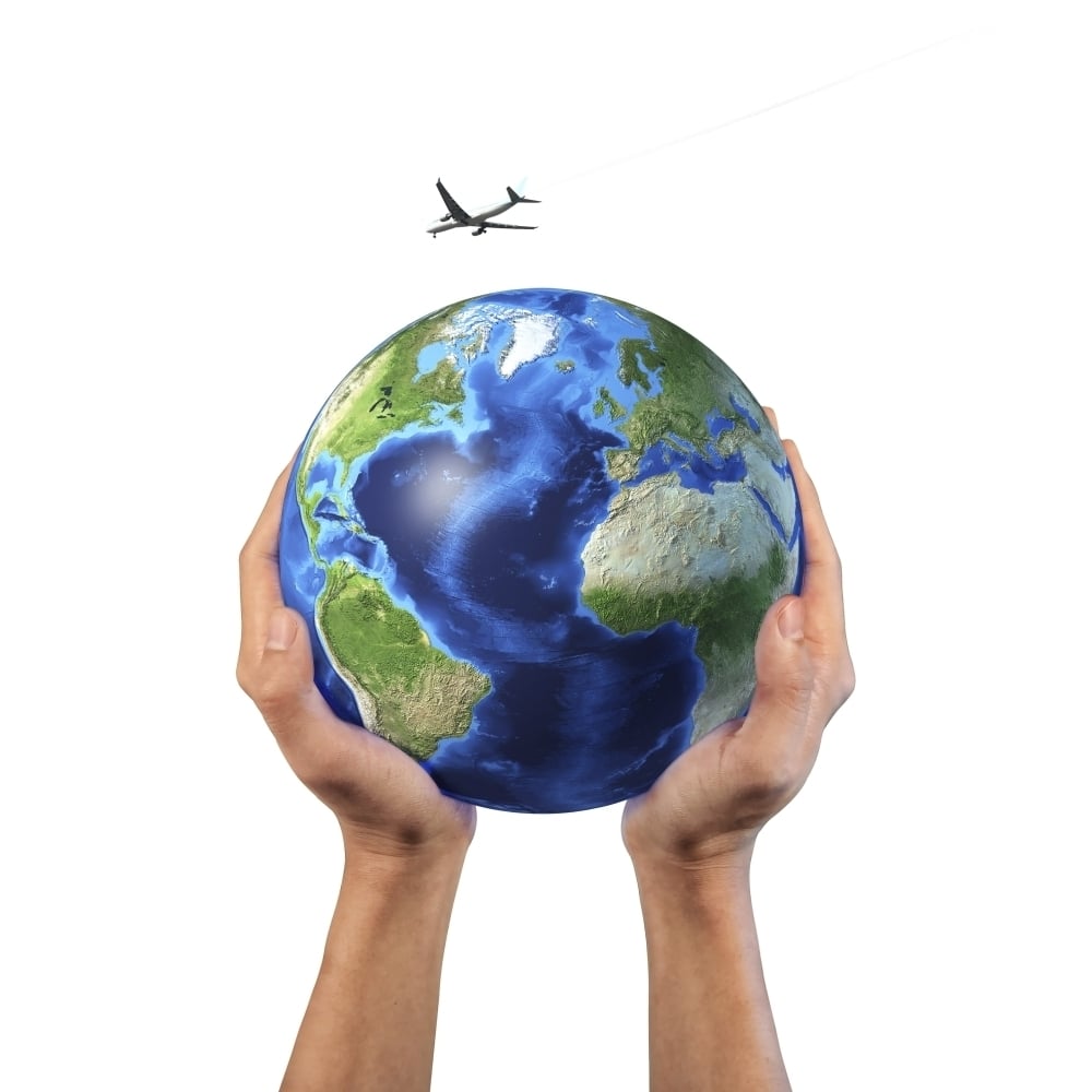 Mans hands holding the planet Earth with a jet aircraft flying above Poster Print Image 2