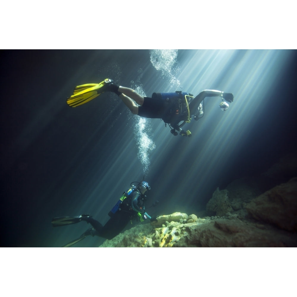 A young married couple scuba diving in Devils Den Springs Florida Poster Print Image 1