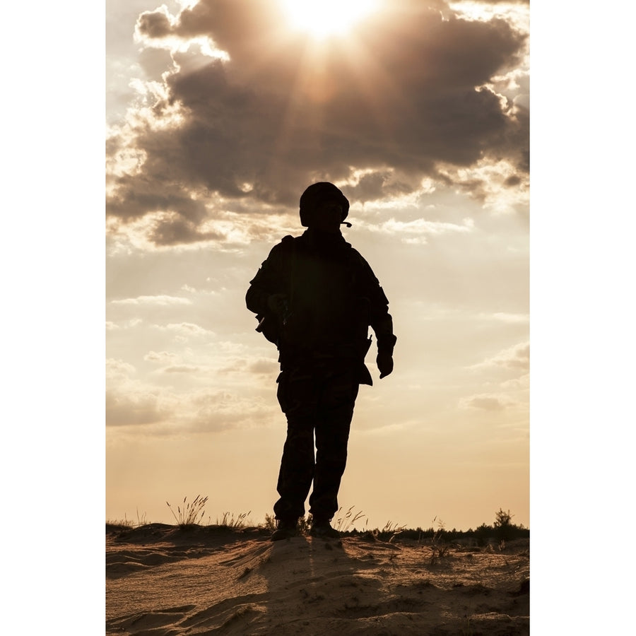 Silhouette of young soldier in military helmet against the sun. Poster Print by Oleg Zabielin/Stocktrek Images Image 1