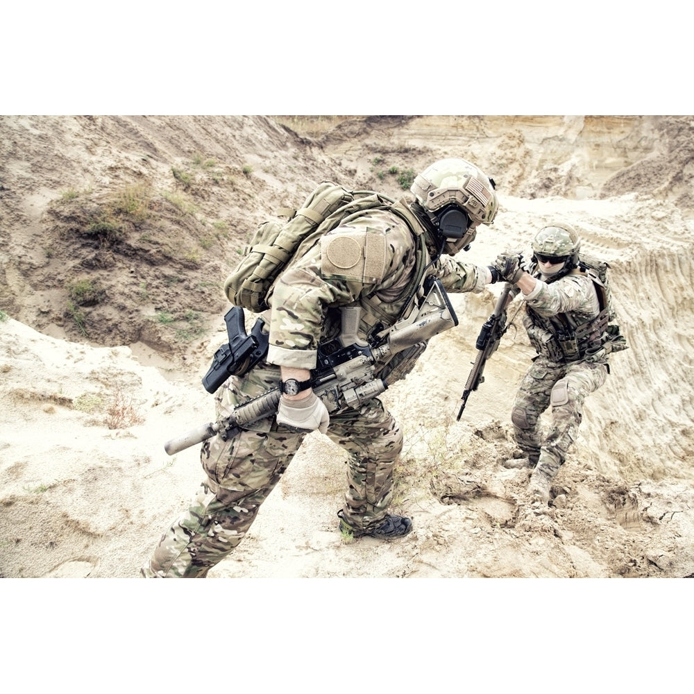 U.S. soldier helping a fellow soldier climb up a sand dune. Poster Print by Oleg Zabielin/Stocktrek Images Image 1