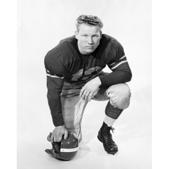 Football player kneeling and holding a football helmet Poster Print Image 2