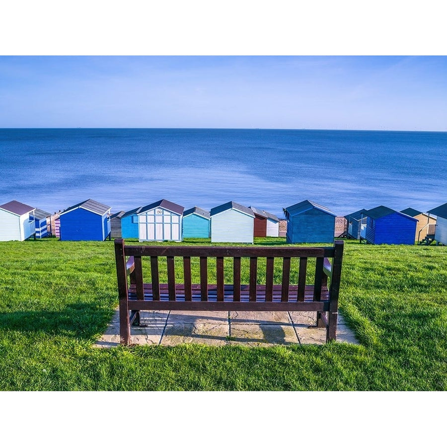 Bench on lawn with beach huts in background by Assaf Frank-VARPDXAF20100406077 Image 1