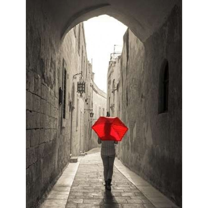 Tourist with umbrella walking through narrow street in Mdina Malta Poster Print by Assaf Image 1